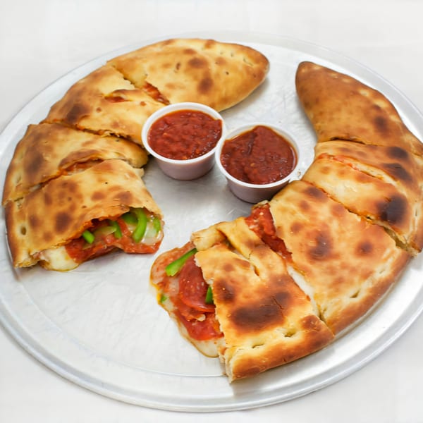 Two calzones, one with green peppers and one with pepperoni, served with two cups of marinara sauce.